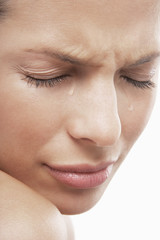 Detailed image of sad young woman with tears isolated on white background