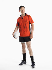 Full length of a rugby player holding ball against white background