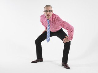Full length of a bald male executive in glasses staring at you against white background