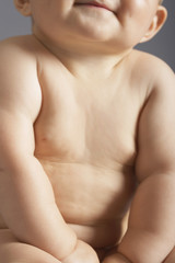 Naklejka premium Midsection of baby girl sitting isolated on colored background