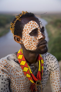 Portrait of a Karo tribesman with facial decoration in chalk imitating the spotted plumage of the guinea fowl, Lower Omo Valley, Ethiopia