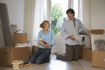 Young couple unpacking boxes at their new home