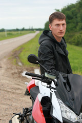 Fototapeta na wymiar Young man near a motorcycle