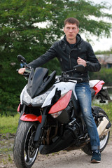Fototapeta na wymiar Young man near a motorcycle