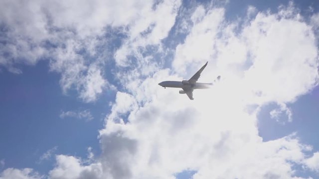 SLOW MOTION: Commercial airplane jet flying over the sun, landing
