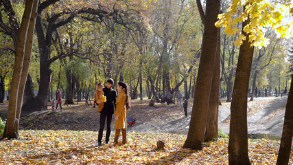 Happy family with a baby in autumn woods
