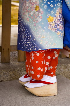 Maiko (apprentice geisha) wearing traditional Japanese kimono and okobo (tall wooden shoes), Kyoto, Kansai region, island of Honshu, Japan