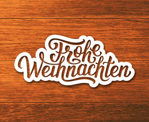 Frohe Weihnachten deutsch text on white paper label with hand lettering over wooden background. Merry Christmas sticker or greeting card vector design template with german inscription