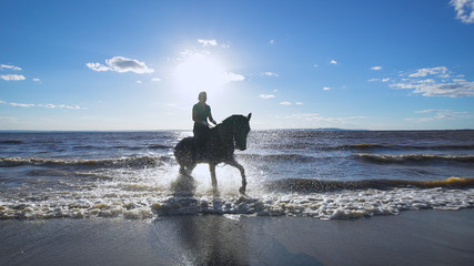 A beautiful woman riding a horse at a lake