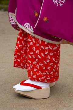 Woman wearing traditional Japanese kimono and okobo (tall wooden shoes), Kyoto, Kansai region, island of Honshu, Japan