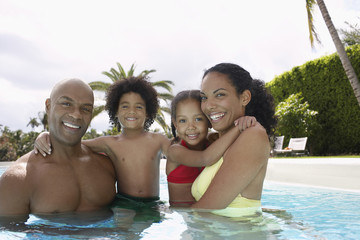 Portrait of happy African American parents with children in swimming pool