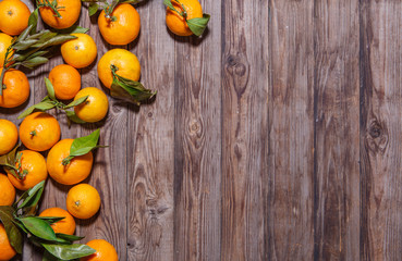 Orange mandarins fruits with leaves on white wooden background