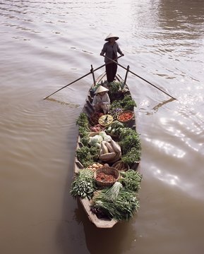 Floating market trader and boat laden with vegetables, Phung Hiep, Mekong River delta, Vietnam