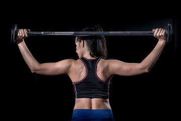 Fototapeta na wymiar Woman bodybuilder lifting barbell isolated over black background