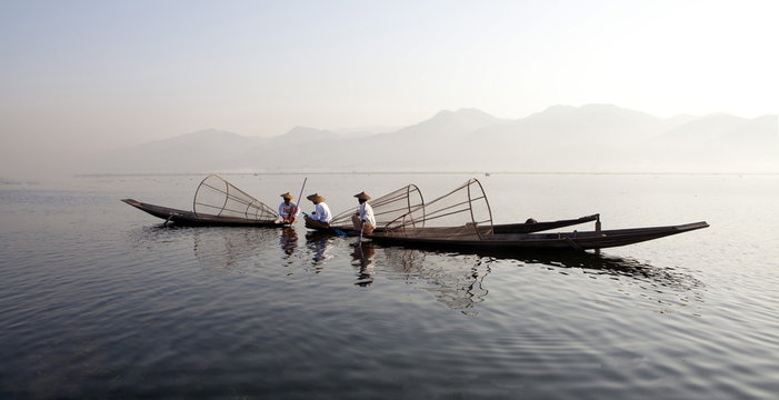 Intha leg rowing fishermen on Inle Lake who row traditional wooden boats using their leg and fish using nets stretched over conical bamboo frames, Inle Lake, Shan State