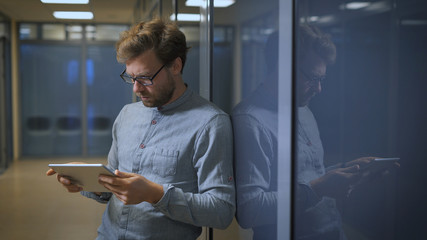 Blonde man in a business center monitors the news on social networks