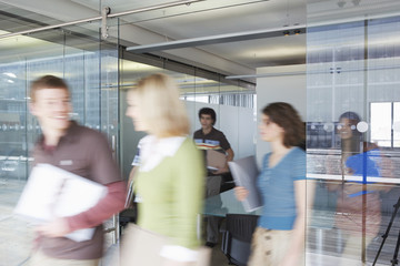 Multiethnic blurred office workers leaving conference room