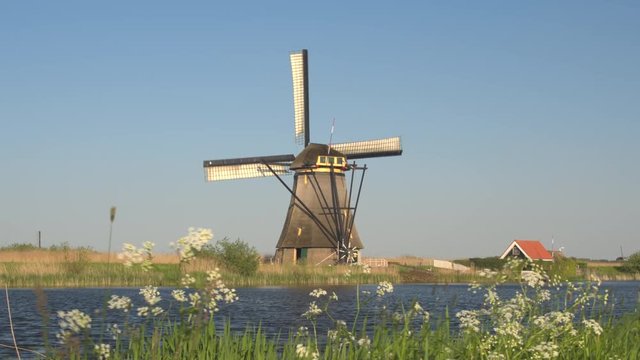 CLOSE UP: Stunning traditional antique wooden windmill next to beautiful river