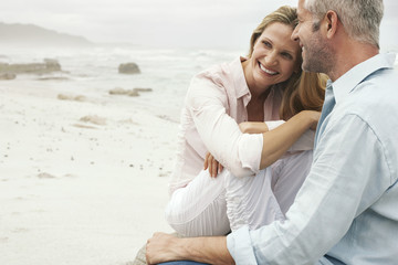 Naklejka premium Szczęśliwa kochająca para siedzi na plaży
