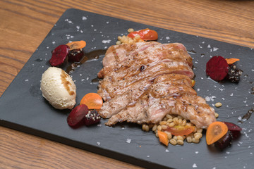 pork steak with vegetable on a granite plate

