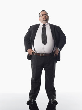 Full length of an overweight businessman standing against white background