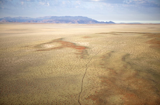 Aerial view from hot air balloon over magnificent desert landscape of sand dunes, mountains and Fairy Circles, Namib Rand game reserve Namib Naukluft Park, Namibia