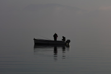 boat with fishermen in winter fog
