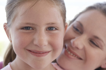Closeup portrait of cute young girl with loving mother