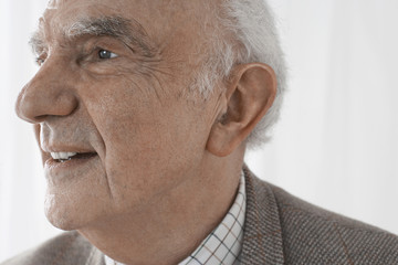 Fototapeta premium Closeup of a smiling senior man against white background
