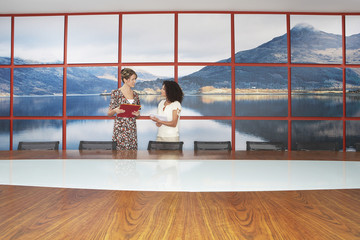 Multiethnic businesswomen standing and talking in modern conference room