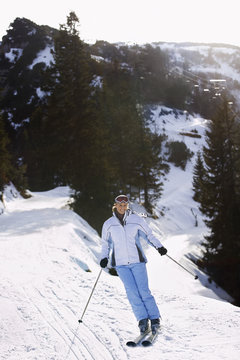 Full length of a woman skiing down slope