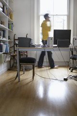 Side view of a blurred man talking on phone at home office