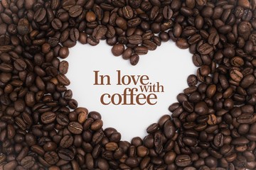 Background made of coffee beans in a heart shape with message 