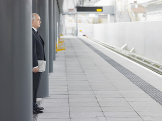 Side view of a mature businessman waiting at an empty train station