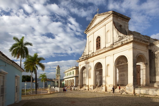 View across Plaza Mayor towards Iglesia de la Santisima Trinidad, the Museo Romantico and the tower of Iglesia y Convento de San Francisco, Trinidad, Cuba