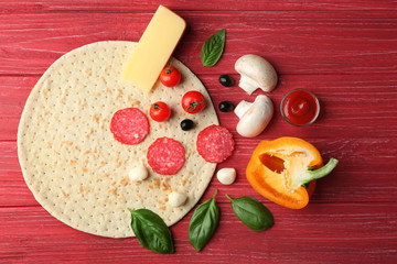 Raw pizza ingredients on wooden background, top view