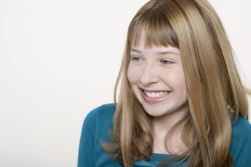 Closeup of a happy teenage girl looking at copyspace over white background
