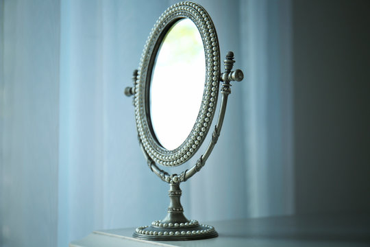 Antique silver mirror on table