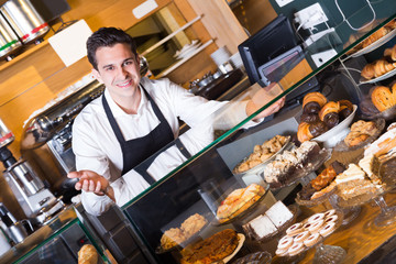 Happy adult man selling tarts and sweet pastry © JackF