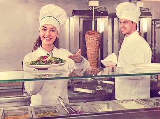Portrait of two hospitable chefs with kebab at fastfood place