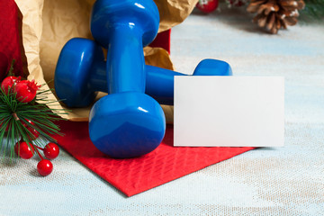 Christmas gift blue sport dumbbells with copyspace business card