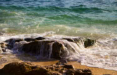 Blue and green sea water and stone beach. Tropical seaside blurry background