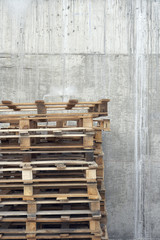 Closeup of a stack of wooden pallets against concrete wall
