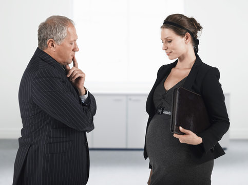 Pregnant businesswoman in front of thoughtful boss in office - Powered by Adobe