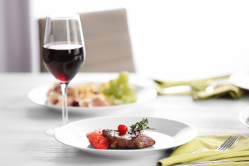 Steak and appetizers with wine on table