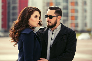 Young fashion couple in love walking on city street