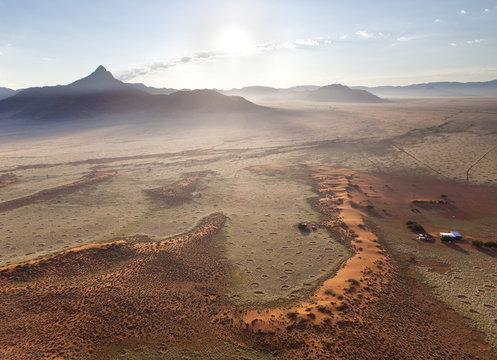 Aerial view from hot air balloon at dawn over magnificent desert landscape of sand dunes, mountains and Fairy Circles, Namib Rand game reserve Namib Naukluft Park, Namibia