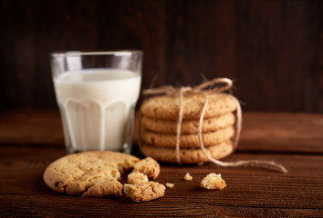 Cookies and milk. Chocolate chip cookies and a glass of milk. Vintage look. Tasty cookies and glass of milk on rustic wooden background. Food, junk-food, culinary, baking and eating concept