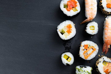 Typical asian cuisine set on black kitchen slate plate.