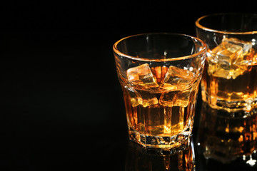 Glasses of whisky on dark background